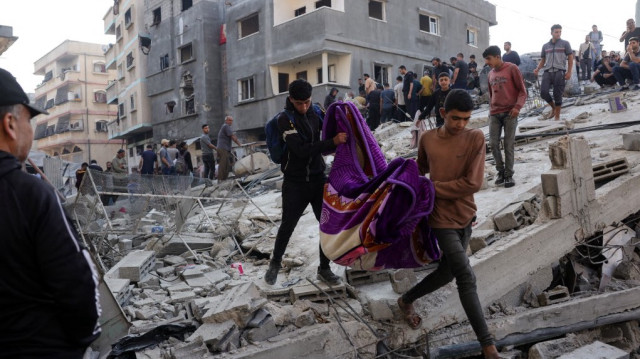 Des Palestiniens portent le corps d'un homme tué lors d'une frappe israélienne dans le quartier de Saftawi, à l'ouest de Jabalia, dans le nord de la bande de Gaza, le 27 mai 2025.