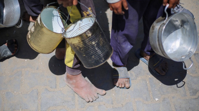 Des enfants palestiniens font la queue pour un repas chaud dans une cuisine de charité gérée par le Programme alimentaire mondial (PAM) des Nations unies dans le camp de réfugiés de Nuseirat, au centre de la bande de Gaza, le 26 avril 2025.