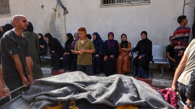 Des personnes portent le corps enveloppé d'une personne tuée lors d'une frappe israélienne à l'hôpital Al-Shifa dans la ville de Gaza le 26 mai 2025.