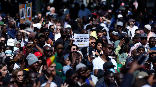 Un manifestant tient une pancarte sur laquelle on peut lire "Le racisme tue, non à la haine des musulmans" lors d'un rassemblement place de la République à Paris le 1er mai 2025, en mémoire d'Aboubakar Cissé, le fidèle tué dans une mosquée de plusieurs dizaines de coups de couteau à La Grand-Combe le 25 avril 2025. Les représentants des institutions musulmanes ont été reçus par le Président de la République le 29 avril 2025 au matin, dénonçant auprès du Président le "climat d'islamophobie ambiant" et appelant à des "actions concrètes" pour les protéger, à la suite d'un meurtre dans une mosquée du Gard.