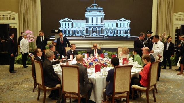 Le président de Singapour, Tharman Shanmugaratnam (au centre), et son épouse Jane Ittogi (en vert) ont organisé un déjeuner officiel en l'honneur du président français Emmanuel Macron (au centre à gauche) et de son épouse Brigitte Macron (au centre à droite) à Singapour le 30 mai 2025.