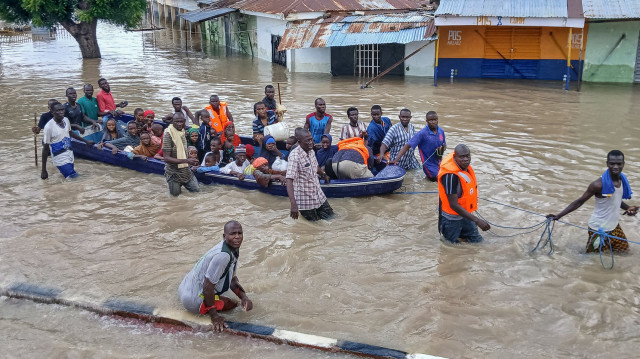 Des personnes touchées par les inondations sont escortées à travers les eaux de crue sur un bateau militaire à Maiduguri le 12 septembre 2024. De graves inondations dans la ville de Maiduguri, au nord-est du Nigéria, ont fait au moins 30 morts et forcé 400 000 personnes à quitter leur domicile, ont indiqué des responsables le 11 septembre 2024.