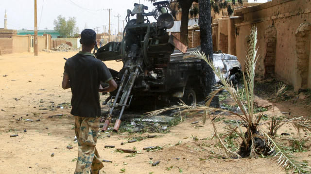 Un soldat de l'armée soudanaise se dirige vers un camion armé laissé par les forces paramilitaires de soutien rapide (RSF), à Salha, au sud d'Omdurman, un jour après l'avoir repris aux RSF, le 21 mai 2025. L'armée soudanaise a déclaré le 20 mai qu'elle avait délogé les paramilitaires rivaux de leurs dernières positions à Omdurman, une partie de la capitale soudanaise, sécurisant ainsi l'ensemble de l'État de Khartoum, près de deux mois après avoir repris le centre de la capitale.