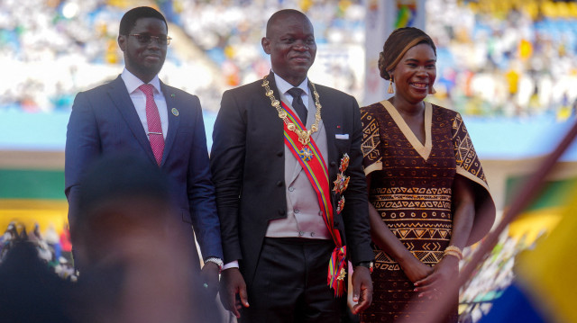 Le président du Gabon, Brice Oligui Nguema (C), pose pour une photo avec la première dame du Gabon, Zita Oligui Nguema (D), et le président du Sénégal, Bassirou Diomaye Faye (G), lors de sa cérémonie de prestation de serment dans un stade de Libreville, le 3 mai 2025. Brice Oligui Nguema, dont le coup d'État a mis fin à 55 ans de règne de la famille Bongo, a prêté serment en tant que président le 3 mai 2025 devant un stade plein à craquer et plus d'une douzaine de dirigeants africains.
