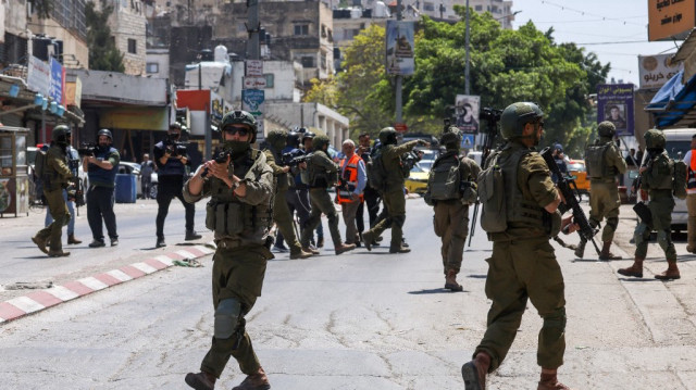 Des soldats israéliens ferment une route lors d'un raid dans le camp d'Al-ain pour les réfugiés palestiniens à l'ouest de Naplouse en Palestine occupée, le 28 avril 2025.