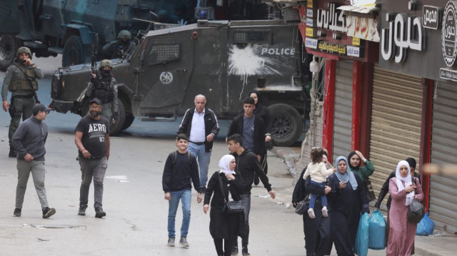 Des soldats israéliens bloquent la route devant des Palestiniens lors d'un raid dans la vieille ville de Naplouse, en Palestine occupée, le 4 mai 2025.