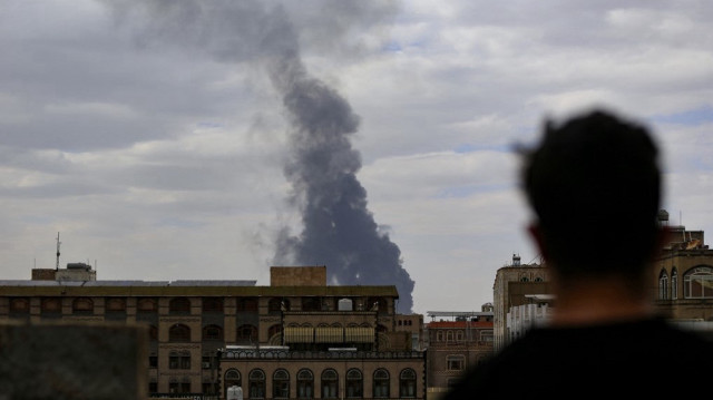 Un homme regarde la fumée s'élever à l'horizon à la suite d'une attaque aérienne israélienne sur Sanaa, la capitale du Yémen tenue par les Huthis, le 6 mai 2025.