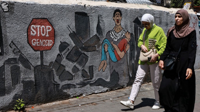 Un homme passe devant une fresque murale représentant la destruction de la bande de Gaza à Ramallah, en Palestine occupée, le 6 mai 2025.