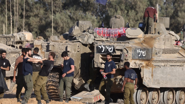 Des soldats israéliens se rassemblent à côté de chars sur une position près de la frontière israélienne avec la bande de Gaza, le 5 mai 2025.