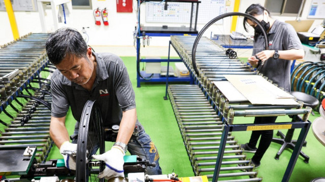 Des ouvriers vérifient la qualité des roues de bicyclettes dans une usine du groupe Joy à Taichung, le 24 avril 2025.