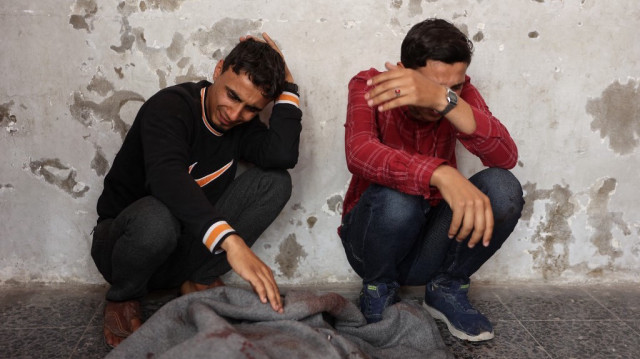 Des Palestiniens pleurent un corps enveloppé dans une couverture à l'hôpital Al-Ahli, également connu sous le nom d'hôpital baptiste ou Ahli Arab, le 7 mai 2025, à la suite d'une frappe israélienne dans la ville de Gaza.