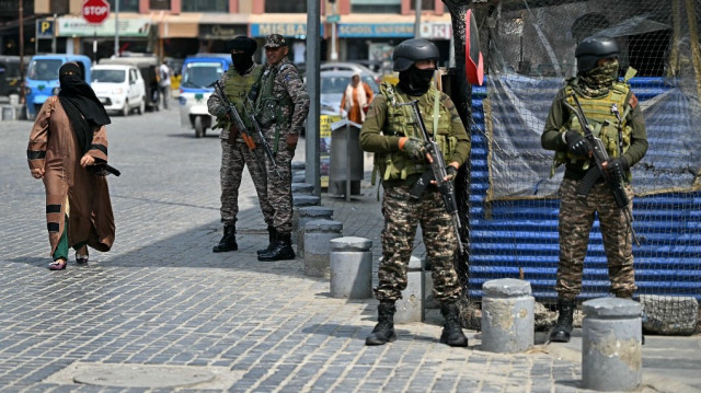 Une femme du Cachemire marche le long d'une route alors que le personnel paramilitaire indien monte la garde à Srinagar le 7 mai 2025, suite aux tensions frontalières.