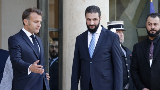 Le président syrien Ahmed al-Sharaa (à droite), entouré du président français Emmanuel Macron (à gauche), quitte le palais de l'Élysée à Paris, le 7 mai 2025, après une conférence de presse conjointe à l'issue d'une réunion.