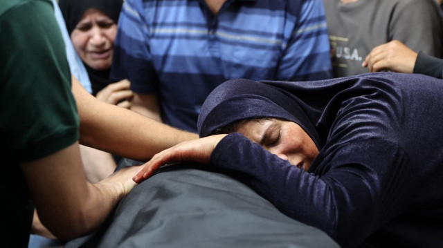Une femme palestinienne réagit devant le corps d'un homme à la morgue de l'hôpital Al-Shifa, suite à une frappe israélienne qui a touché le restaurant thaïlandais de la ville de Gaza et ses environs, le 7 mai 2025.