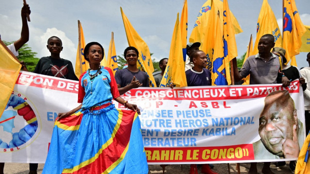 Des partisans tiennent des drapeaux du Parti du peuple pour la reconstruction et la démocratie (PPRD), une structure politique créée par l'ancien président de la RD Congo, Joseph Kabila, alors qu'ils se rassemblent dans la capitale Kinshasa, le 16 janvier 2019, à l'occasion du 18e anniversaire de l'assassinat de son père et ancien président, Laurent-Désiré Kabila.