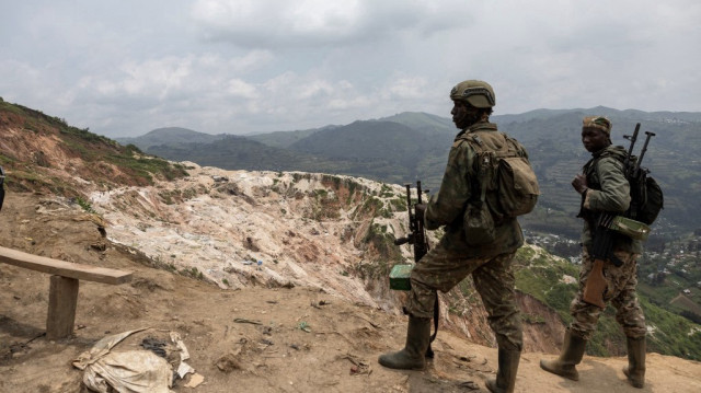 Des soldats du M23 se tiennent devant les puits miniers de Rubaya, le 5 mars 2025. Ravagé par un conflit depuis 30 ans, l'est de la RDC détiendrait entre 60 et 80 % des réserves mondiales de coltan, un minerai essentiel pour la fabrication d'équipements électroniques.