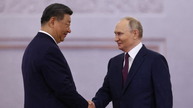 Le président russe Vladimir Poutine et son homologue chinois Xi Jinping se serrent la main lors d'une cérémonie de bienvenue avant leur entretien au Kremlin, à Moscou, le 8 mai 2025.