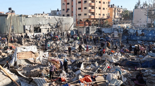 Des Palestiniens examinent les abris détruits dans une école de l'UNRWA accueillant des personnes déplacées, à la suite d'une attaque israélienne dans le camp de réfugiés de Bureij, au centre de la bande de Gaza, le 7 mai 2025.