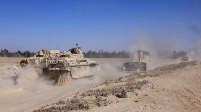 Cette photo prise près de la frontière israélienne avec Gaza montre des véhicules blindés et des bulldozers israéliens revenant du territoire palestinien assiégé, le 8 mai 2025, dans le cadre de la guerre entre Israël et le mouvement militant palestinien Hamas.