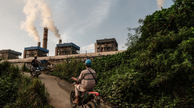 Des ouvriers circulent à moto le matin pour entrer dans le parc industriel de Weda Bay (WBIP), un important centre de traitement et de fusion du nickel, à Lelilef Sawai, Halmahera central, Maluku du Nord.