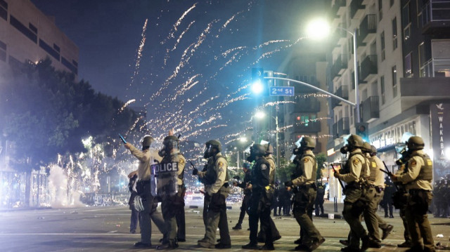 Un feu d'artifice explose près d'une patrouille de police alors que les manifestations se poursuivent à Los Angeles après trois jours d'affrontements avec la police suite à une série de raids sur l'immigration, le 09 juin 2025 à Los Angeles, Californie.
