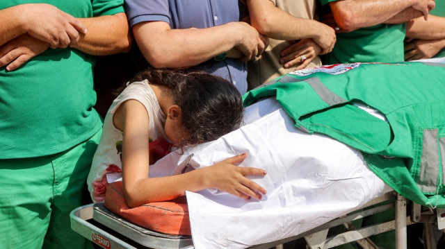 Une jeune fille pleure le corps d'un des trois ambulanciers tués la veille par un bombardement israélien sur le quartier de Tuffah, lors des funérailles à la clinique Sheikh Radwan dans le quartier Sheikh Radwan de la ville de Gaza, le 10 juin 2025.