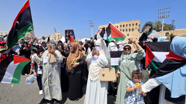 Des Libyens agitent des drapeaux en accueillant des militants qui se dirigent vers Gaza par voie terrestre dans le but de briser le siège du territoire palestinien, sur la place des Martyrs de Tripoli, le 11 juin 2025.