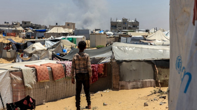 Un enfant palestinien regarde la fumée s'échapper au loin lors d'un bombardement israélien à Rafah, dans le sud de la bande de Gaza, le 11 juin 2025.