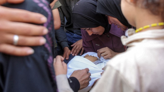 Une femme pleure le corps d'une victime tuée lors d'un bombardement israélien pendant la nuit alors qu'elle est assise avec d'autres personnes en deuil à l'hôpital Al-Shifa dans la ville de Gaza, le 4 juin 2025.