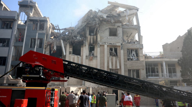 Des équipes de secours travaillent à l'extérieur d'un bâtiment lourdement endommagé, visé par une frappe israélienne dans la capitale iranienne Téhéran, le 13 juin 2025.