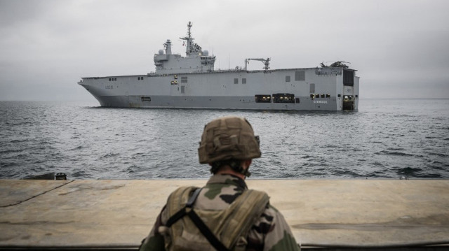 Une barge arrive à bord du porte-hélicoptères "Dixmude" de la marine française, navire amiral de la flotte, pour charger les soldats et les véhicules des forces terrestres en vue de leur débarquement sur une plage dans le cadre de l'opération POLARIS 25 (Préparation opérationnelle en lutte aéromaritime, résilience, innovation et supériorité), à Plouhinec, dans l'ouest de la France, le 12 juin 2025.