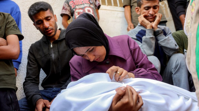 Une femme pleure le corps d'une victime qui a été tuée lors d'un bombardement israélien pendant la nuit alors qu'elle est assise avec d'autres personnes en deuil à l'hôpital Al-Shifa dans la ville de Gaza le 4 juin 2025.