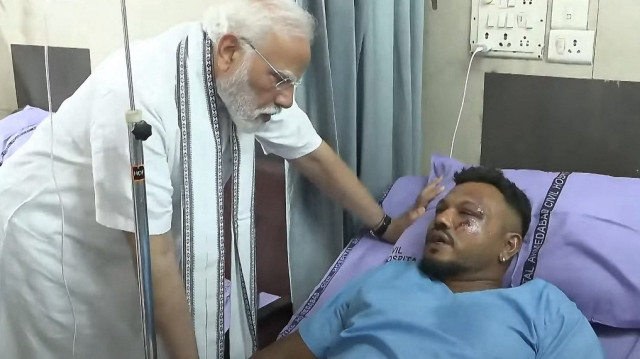 Cette capture d'écran d'une vidéo prise et publiée par la chaîne Youtube Narendra Modi le 13 juin 2025 montre le Premier ministre indien Narendra Modi (à gauche) rencontrant Vishwash Kumar Ramesh, seul survivant de l'accident du vol 171 d'Air India, dans un hôpital d'Ahmedabad.