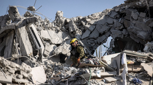 Des secouristes israéliens inspectent un site touché par un missile tiré depuis l'Iran au sud de Tel Aviv, le 14 juin 2025. L'Iran a frappé Israël tôt le 14 juin, avec des barrages de missiles, après un assaut massif visant les installations nucléaires et militaires de la république islamique, et tuant plusieurs généraux de haut rang.