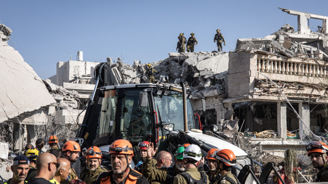 Des secouristes israéliens inspectent un site touché par un missile tiré depuis l'Iran au sud de Tel Aviv, le 14 juin 2025. L'Iran a frappé Israël tôt le 14 juin, avec des barrages de missiles, après un assaut massif visant les installations nucléaires et militaires de la république islamique, et tuant plusieurs généraux de haut rang.