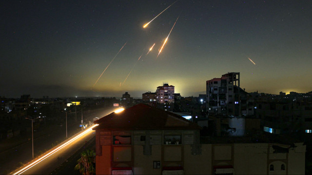 Cette photo prise à Nuseirat, dans le centre de la bande de Gaza, montre des traînées de roquettes dans le ciel, le 13 juin 2025, après que l'Iran a frappé Israël avec des barrages de missiles à la suite d'un assaut massif visant les installations nucléaires et militaires de la république islamique.