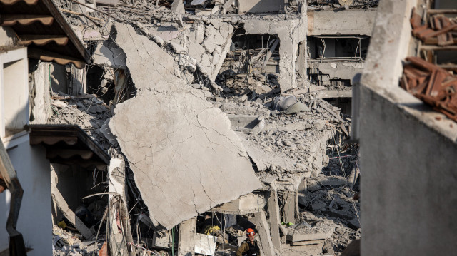 Des secouristes israéliens inspectent un site touché par un missile tiré depuis l'Iran au sud de Tel Aviv, le 14 juin 2025. L'Iran a frappé Israël tôt le 14 juin, avec des barrages de missiles, après un assaut massif visant les installations nucléaires et militaires de la république islamique, et tuant plusieurs généraux de haut rang.