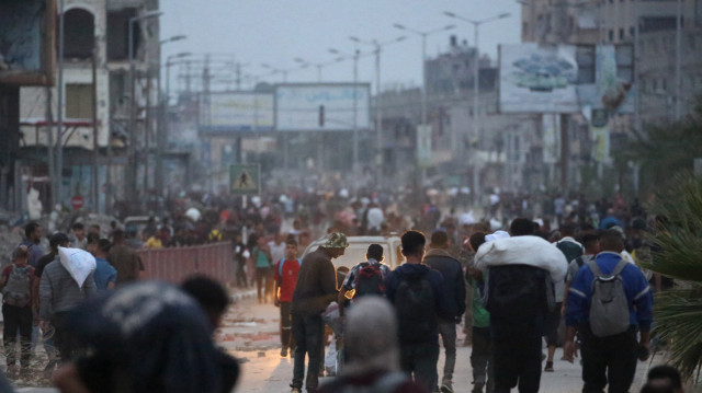 Des Palestiniens ramènent de l'aide humanitaire d'un point de distribution dans le camp de réfugiés palestiniens de Bureij, dans le centre de la bande de Gaza, le 9 juin 2025.