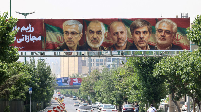 Une affiche montrant les portraits de généraux militaires et de scientifiques nucléaires iraniens, tués lors de l'attaque israélienne du 13 juin, est accrochée sur un pont à Téhéran le 14 juin 2025. L'armée israélienne a déclaré que ses avions de combat étaient prêts à reprendre leurs frappes sur des cibles à Téhéran, après avoir annoncé qu'ils avaient touché des défenses aériennes dans la capitale iranienne pendant la nuit. Israël et l'Iran échangent des coups de feu avec une telle intensité pour la première fois après des décennies d'inimitié et de conflit par procuration, avec la crainte d'un conflit prolongé qui engloutirait la région.