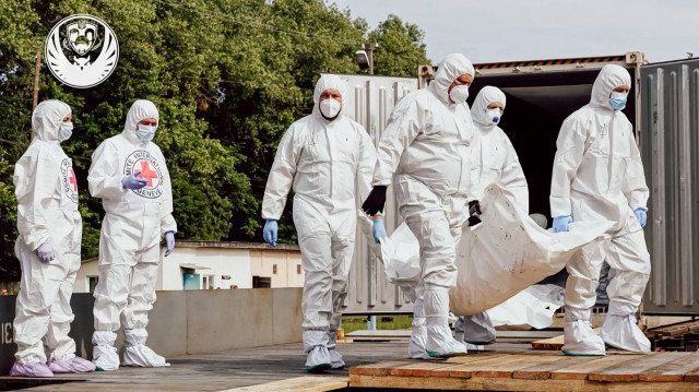 Cette photographie diffusée le 15 juin 2025 par le Quartier général de coordination pour le traitement des prisonniers de guerre montre des employés du Comité international de la Croix-Rouge déchargeant ce qui serait les corps de citoyens ukrainiens, y compris de militaires, renvoyés par la Russie, d'un wagon frigorifique dans un lieu non divulgué en Ukraine, dans le contexte de l'invasion russe en Ukraine. Kiev a déclaré avoir reçu de la Russie un autre lot de 1 200 corps non identifiés qui, selon la Russie, "appartiennent à des citoyens ukrainiens, y compris du personnel militaire", dans le cadre des accords d'Istanbul.