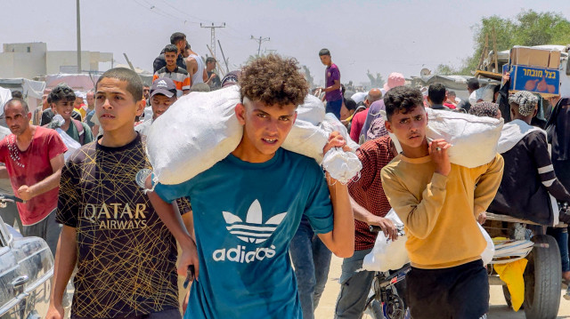 Des Palestiniens déplacés reçoivent des colis d'aide humanitaire d'une fondation soutenue par les États-Unis à Rafah, dans le sud de la bande de Gaza, le 10 juin 2025. Israël a récemment autorisé la reprise de certaines livraisons d'aide à Gaza, après les avoir interdites pendant plus de deux mois, et a commencé à travailler avec la Fondation humanitaire de Gaza (GHF), nouvellement créée et soutenue par les États-Unis. Mais les agences humanitaires ont critiqué la GHF et les Nations unies refusent de travailler avec elle, invoquant des inquiétudes quant à ses pratiques et à sa neutralité.