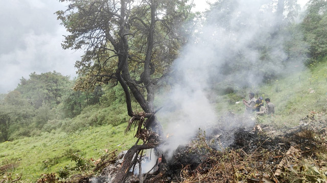 Cette photo prise le 15 juin 2025 et diffusée par la State Disaster Response Force (SDRF) de l'État indien de l'Uttarakhand montre la fumée s'échappant du site de l'accident d'un hélicoptère près de Gaurikund. Sept personnes, dont un enfant en bas âge, ont été tuées le 15 juin en Inde lorsqu'un hélicoptère transportant des pèlerins hindous de retour d'un sanctuaire s'est écrasé dans l'Himalaya, ont indiqué des responsables.
