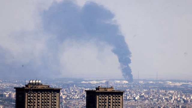 Des volutes de fumée s'élèvent au loin d'une raffinerie de pétrole après une frappe israélienne sur Téhéran, la capitale iranienne, le 17 juin 2025.