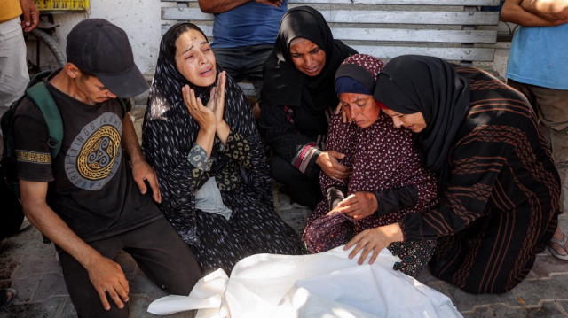 Des femmes se recueillent devant le corps d'une personne tuée à la suite d'attaques israéliennes contre des files d'attente dans la zone de Sudaniya, au nord-ouest de Gaza, à l'hôpital Al-Shifa, dans la ville de Gaza, le 14 juin 2025.