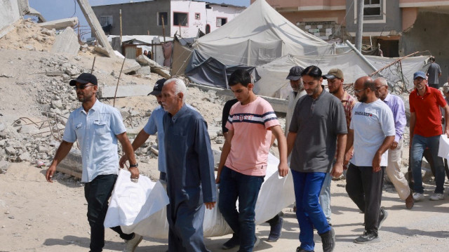 Des Palestiniens portent le corps d'un membre de leur famille, tué lors de frappes israéliennes, pendant leurs funérailles à Khan Yunis, dans le sud de la bande de Gaza, le 16 juin 2025.