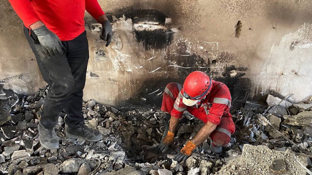 Cette photo diffusée par le Croissant-Rouge iranien le 17 juin 2025 montre des membres de leurs équipes de secours fouillant les débris à l'intérieur d'un bâtiment à Téhéran, visé par des frappes israéliennes.