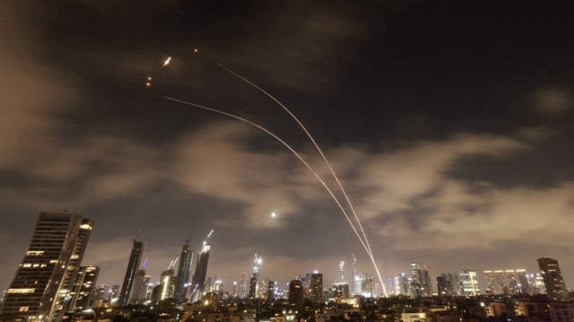 Les systèmes de défense aérienne israéliens sont activés pour intercepter des missiles iraniens au-dessus de la ville israélienne de Tel Aviv, le 18 juin 2025. Israël et l'Iran ont de nouveau échangé des tirs le 17 juin, au cinquième jour des frappes dans leur confrontation la plus intense de l'histoire, alimentant les craintes d'un conflit prolongé qui pourrait embraser le Moyen-Orient.