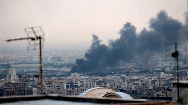 De la fumée s'échappe d'une explosion près de la tour Azadi (à gauche) à Téhéran, le 16 juin 2025.