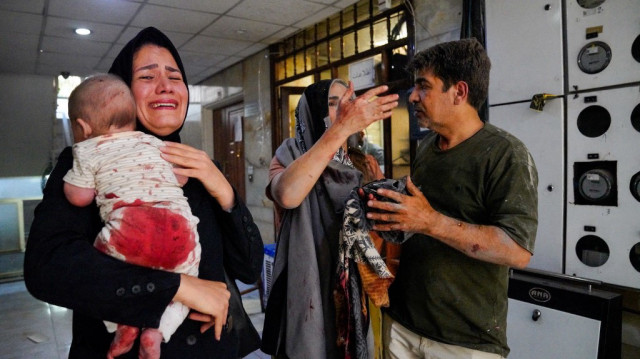Des Iraniens blessés lors d'une frappe israélienne sur le boulevard Keshavarz, dans le centre de Téhéran, réagissent sur le site, le 15 juin 2025.