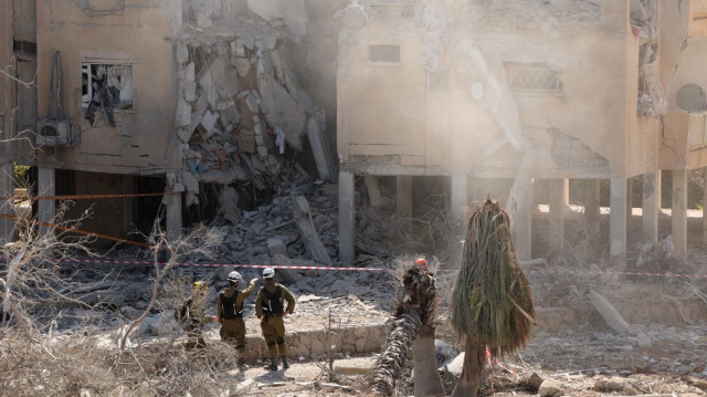Les services d'urgence israéliens vérifient un bâtiment détruit sur le site d'une attaque de missiles iraniens dans un quartier résidentiel de Holon, dans le centre d'Israël, le 19 juin 2025.